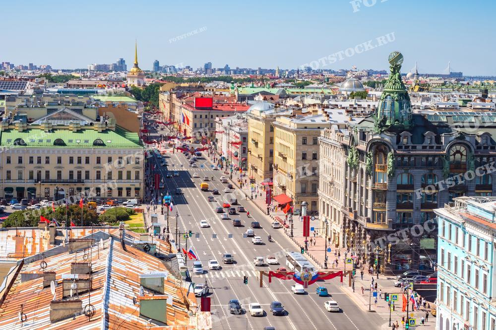 Эта фотография представляет собой панораму центральной улицы Санкт-Петербурга - Невского проспекта, снятую с высоты птичьего полета в ясный день. Изображение захватывает густую урбанистическую застройку, оживленное движение на дорогах и характерные архитектурные детали, такие как знаменитый зеленый купол Дома компании "Зингер". Фотография может быть использована в городских исследованиях, туристических буклетах и как часть экспозиционных материалов.